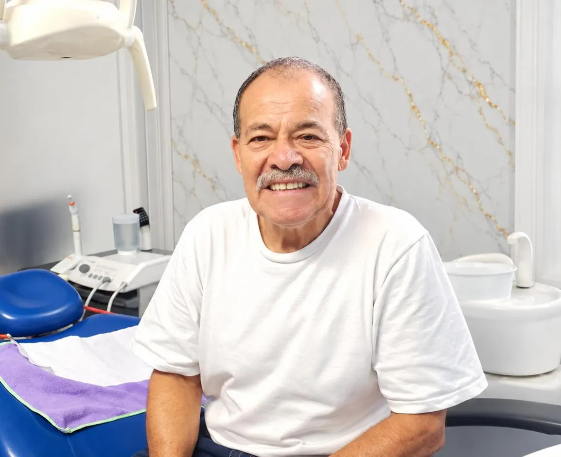 Paciente sonriendo con confianza en el sillón dental de Esthetic Dent