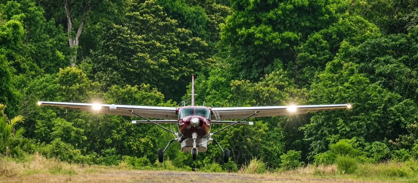 Costa Rica Green Airways aircraft arriving at Cóbano with a tropical landscape in the background