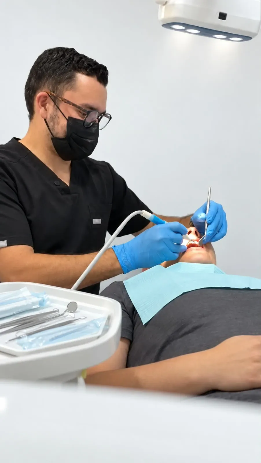 Paciente durante una limpieza dental profesional, con el odontólogo utilizando instrumentos de profilaxis