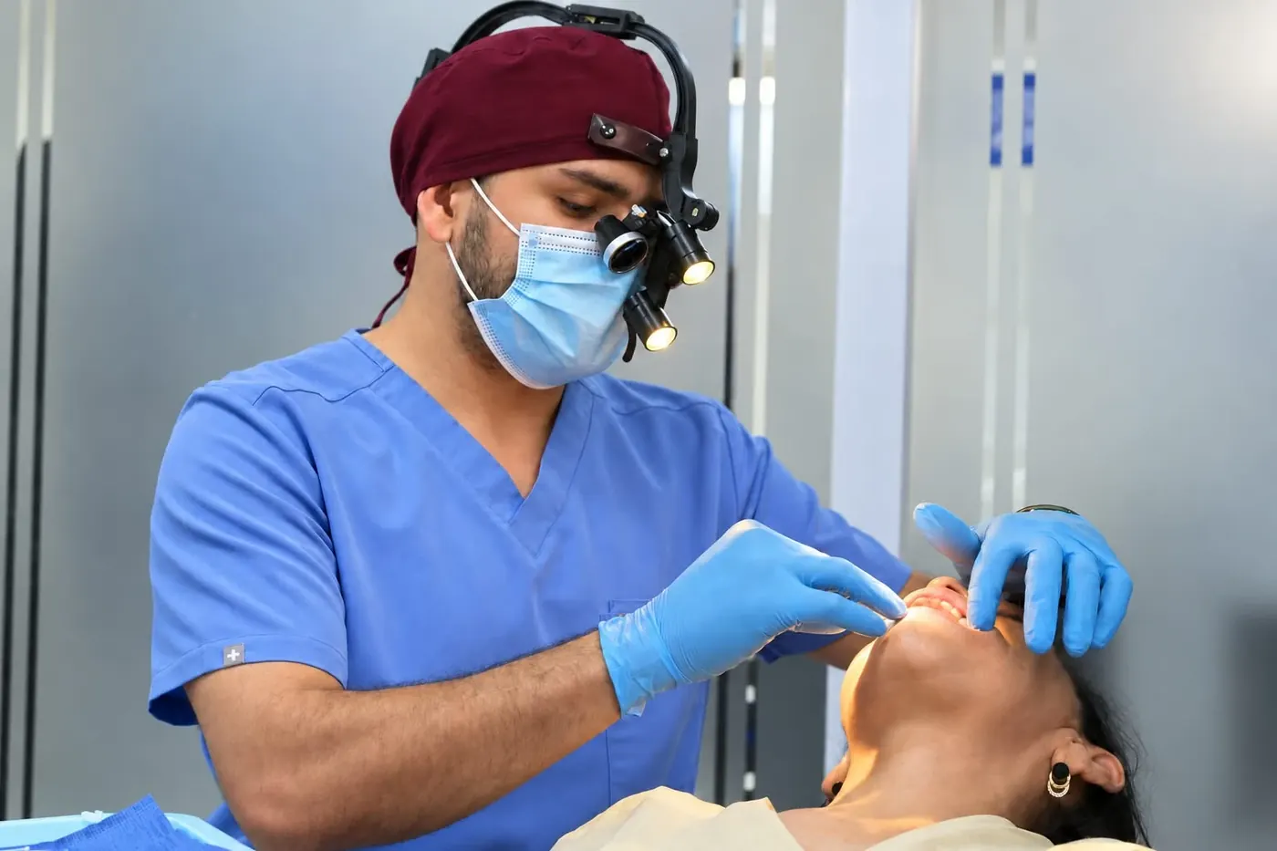 Odontólogo examinando la boca de una paciente para evaluar si es candidata a un tratamiento sobre implantes
