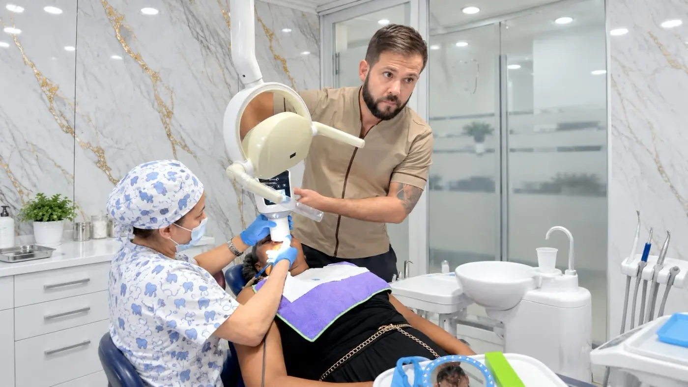 Odontólogo utilizando equipo de radiografía digital para planificar el tratamiento de una paciente