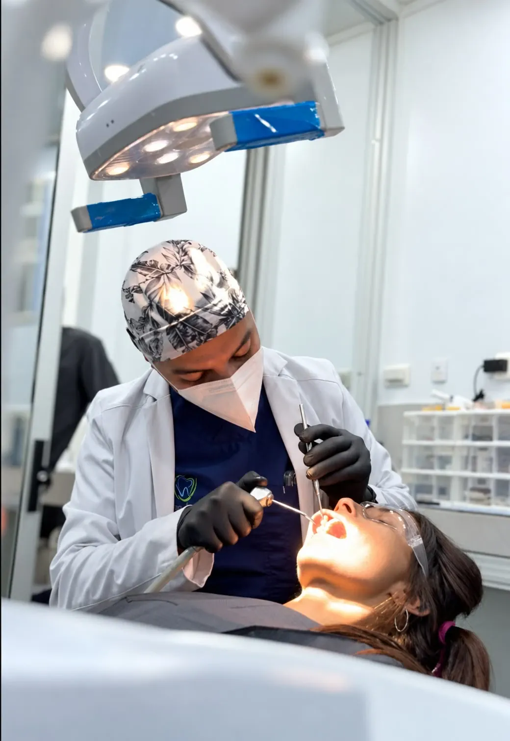 Odontólogo realizando un procedimiento dental a una paciente en el consultorio